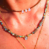 Collier ANTARA Ginandger obsidienne porté en superposition au soleil - gouttes d'opale irisées, look été pierres naturelles
