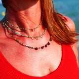 Collier DEEPTI Ginandger porté au bord de la mer en superposition - turquoises et citrines, look été
