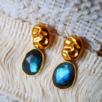Boucles d'oreilles KAVACHA Ginandger posées sur macramé – labradorites bleues facettées serties or et puces dorées martelées ondulées, bijou pierres naturelles fait main à Paris
