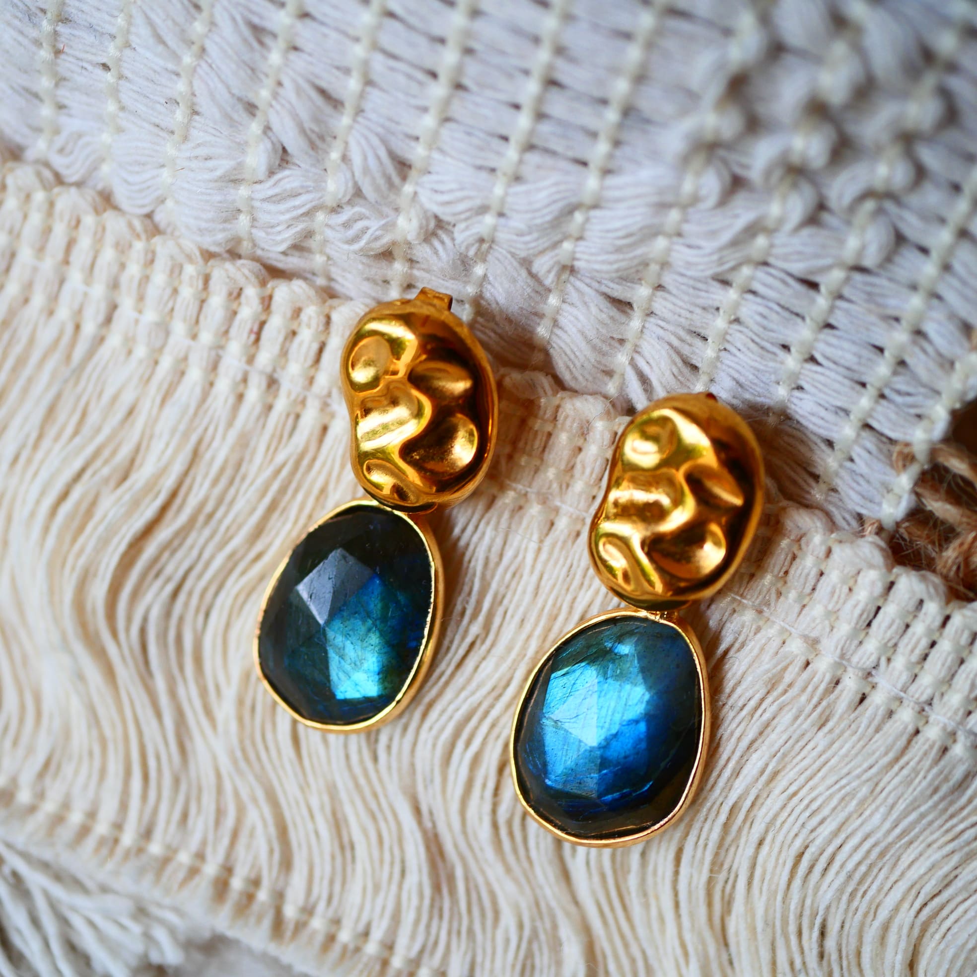 Boucles d'oreilles KAVACHA Ginandger sur macramé blanc – labradorites bleues et vertes facettées, puces dorées martelées, boucles artisanales pierres naturelles Paris
