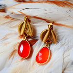 Boucles d'oreilles VEGA Ginandger posées sur plumes – cornalines facettées rouge-orangé serties or et puces feuille dorées texturées, bijou pierres naturelles fait main à Paris
