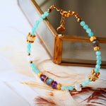 Bracelet LAKSHYA Ginandger sur plumes et miroir doré – détail des amazonites bleu-vert, améthystes et citrines facettées, perles dorées, bracelet pierres naturelles Ginandger
