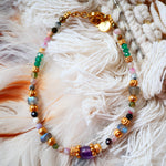 Bracelet THIRA Ginandger sur plumes blanches – camaïeu de tourmalines roses et vertes, labradorites, améthystes et onyx facettés, perles dorées ciselées, bracelet pierres naturelles Ginandger
