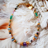 Bracelet THIRA Ginandger sur plumes blanches – camaïeu de tourmalines roses et vertes, labradorites, améthystes et onyx facettés, perles dorées ciselées, bracelet pierres naturelles Ginandger
