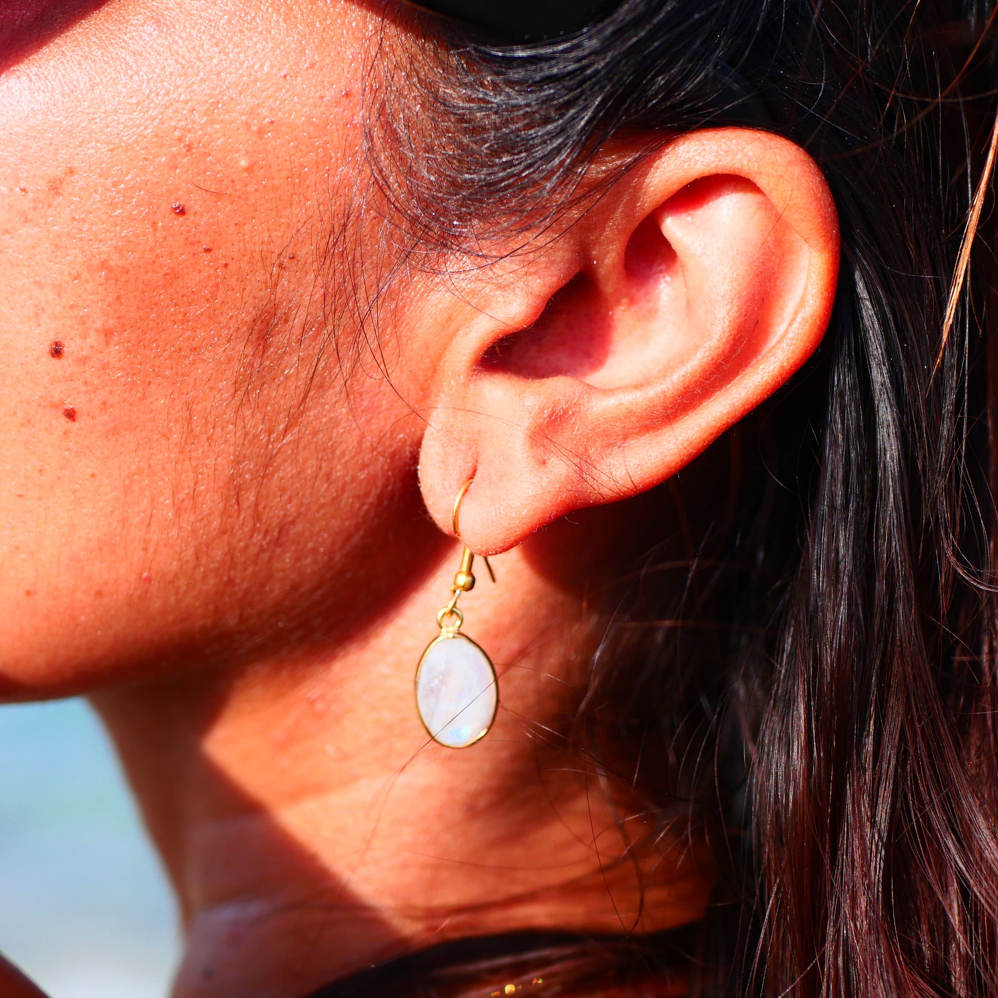 Boucles d'oreilles KAUMUDI Ginandger sur macramé blanc – pierres de lune ovales irisées serties or, crochet doré, boucles artisanales pierres naturelles Paris
