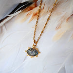 Collier AJNA Ginandger labradorite - pendentif œil sculpté bleu irisé serti or, fond plumes blanches
