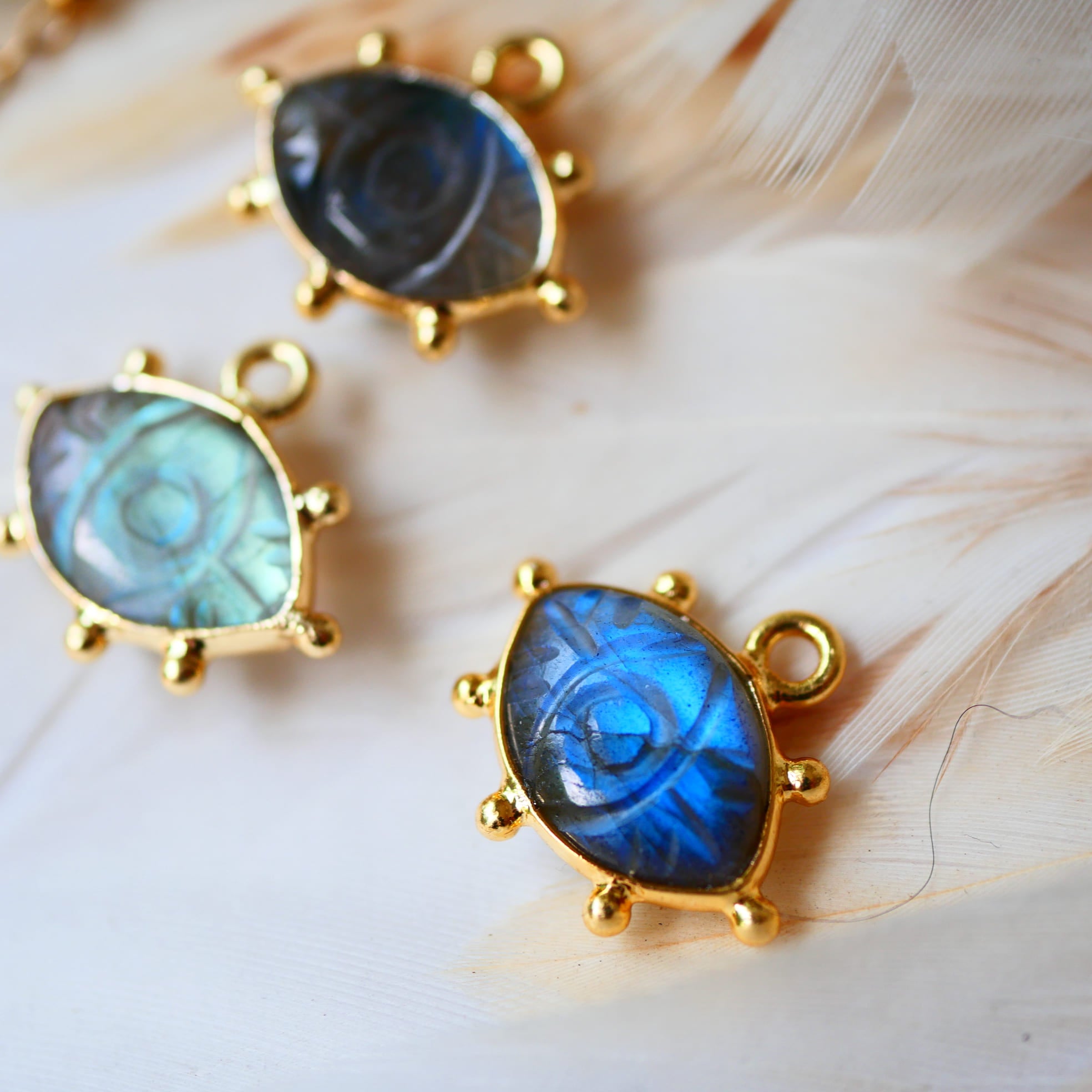 Collier AJNA Ginandger labradorite - pendentif œil sculpté sur chaîne dorée, fond plumes naturelles
