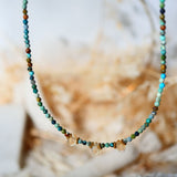 Collier DEEPTI Ginandger suspendu - perles de turquoise facettées et gouttes de citrine, fond floral naturel
