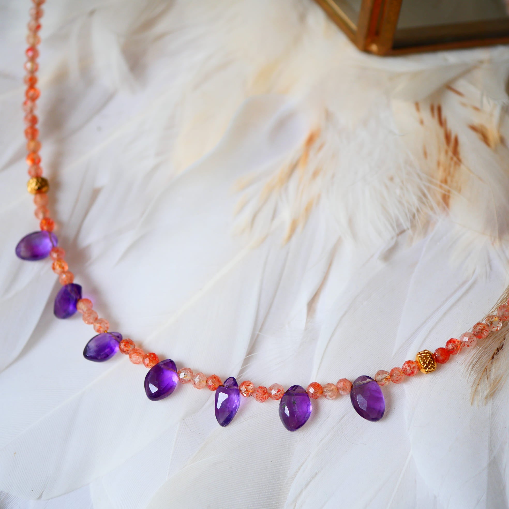 Collier UDAYA Ginandger - détail gouttes d'améthyste et perles de pierre de soleil sur plumes blanches
