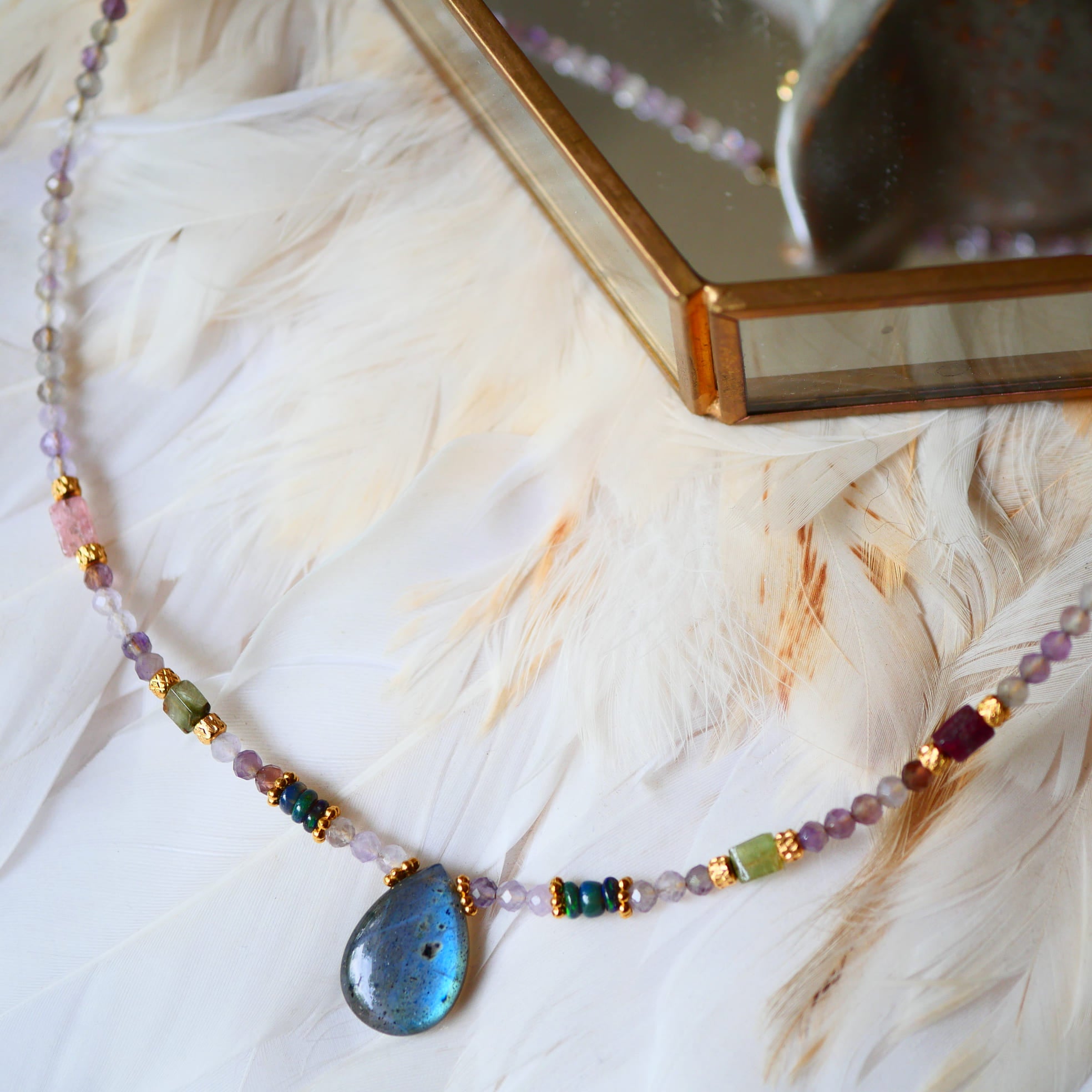 Collier VICHITRA Ginandger - rang multipierre améthyste et pendentif labradorite bleu irisé, fond plumes et écrin doré
