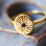 Détail du symbole soleil gravé et du grenat naturel – bague RAVI collection Indra Ginandger
